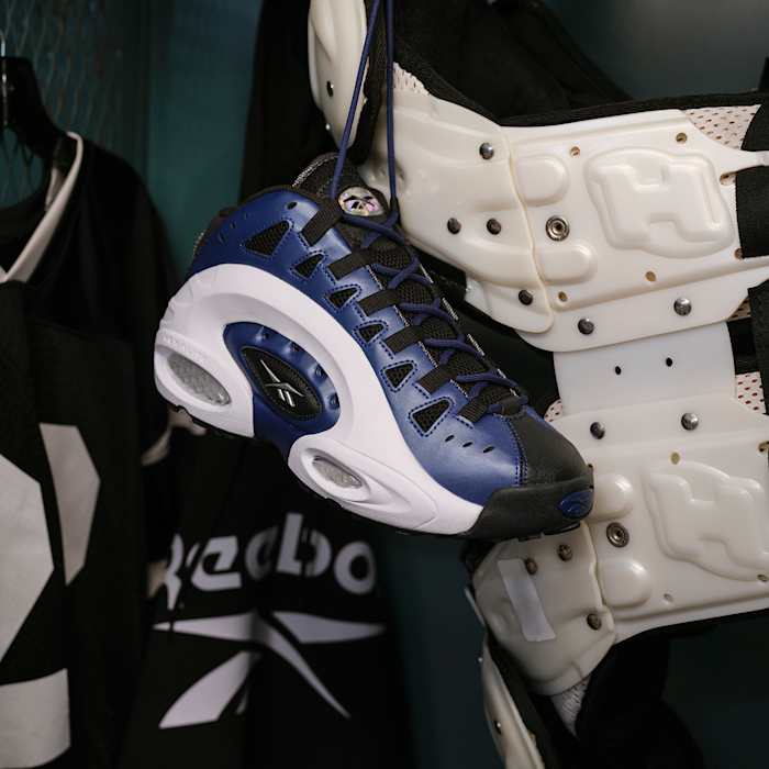 Side view of Emmitt Smith's blue, black, and white Reebok shoes.